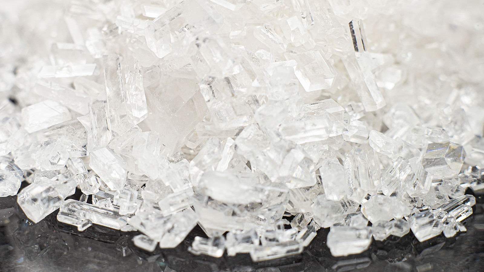 Oktogen (HMX) w postaci przejrzystych kryształów o licznych płaskich powierzchniach i ostrych krawędziach. Źródło: NITRO-CHEM S.A. — Oktogen (HMX), zdjęcie producenta, dostęp 29.07.2026.