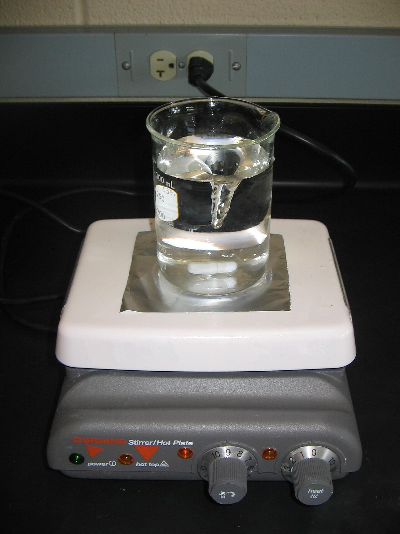 Płyta grzejna z mieszadłem magnetycznym — legalne wyposażenie laboratoryjne. Źródło: Wikimedia Commons, dostęp 29.07.2026.